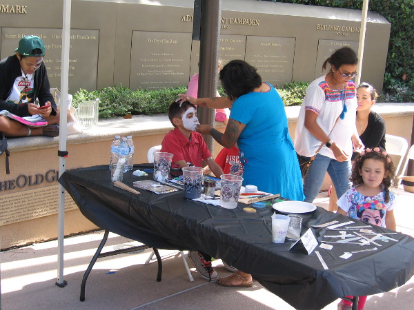 Kids have their faces painted like sugar skulls for Dia de los Muertos.