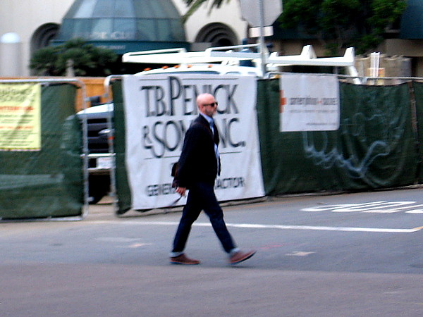 Someone walks briskly to work in downtown San Diego.