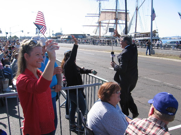 Dave Scott of KUSI television fires up people waiting in the bleachers.
