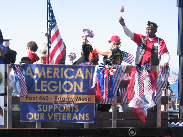 Flags raised high from the American Legion truck. They proudly support our Veterans.