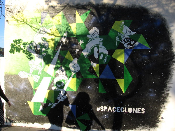 Marvin the Martian, lurking in a mural, awaits two unsuspecting people who are walking down a Little Italy sidewalk.