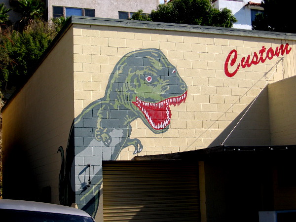 A colorful dinosaur on the building of Dyno Brand custom t-shirts!
