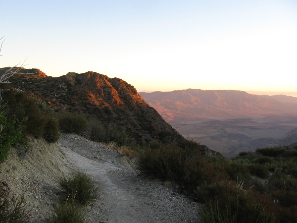 Early sunlight touches a rocky rise.