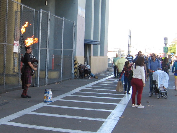 A street musician on San Diego's always dynamic Embarcadero plays bagpipes that shoot flames!