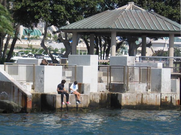 Feet dangle over the water at Embarcadero Marina Park North.