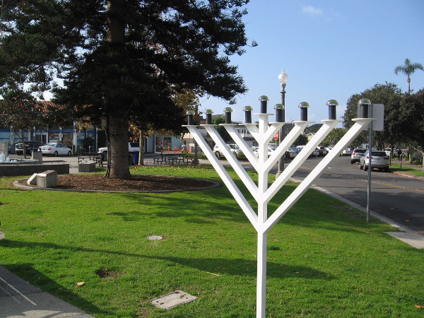 A Hanukkah menorah stands in Rotary Plaza during the holiday season. (The trunk of the large Coronado star pine Christmas tree is in the background.)
