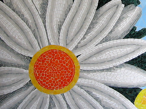 A beautiful sunflower-like zinnia made of small yellow, gold and white tiles.