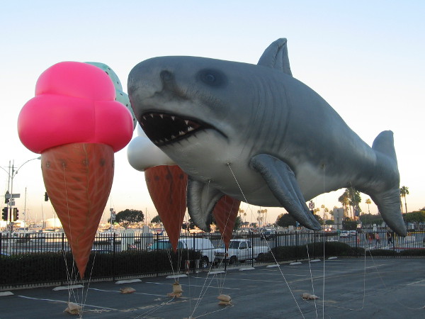 A gigantic shark prepares to take a bite from an enormous strawberry ice cream cone!