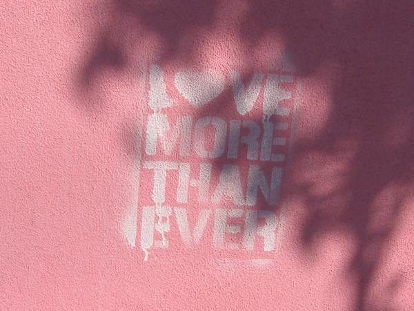 Love More Than Ever stenciled on a wall.