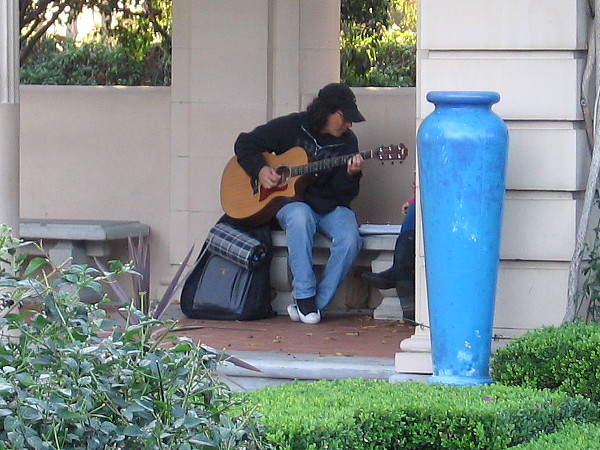 Playing guitar in a nook in the Alcazar Garden.