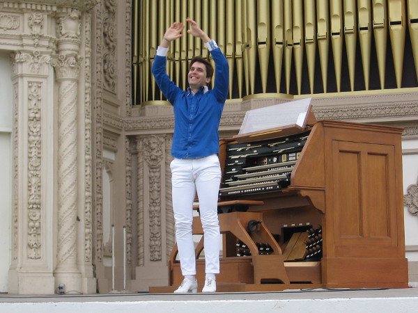 Raúl Prieto Ramírez, San Diego's new Civic Organist, raises his arms in greeting.