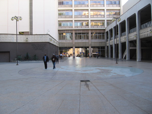 A few people stroll through Civic Center Plaza. Windows in the old (and many say outdated) City Administration Building rise over a passage to C Street.