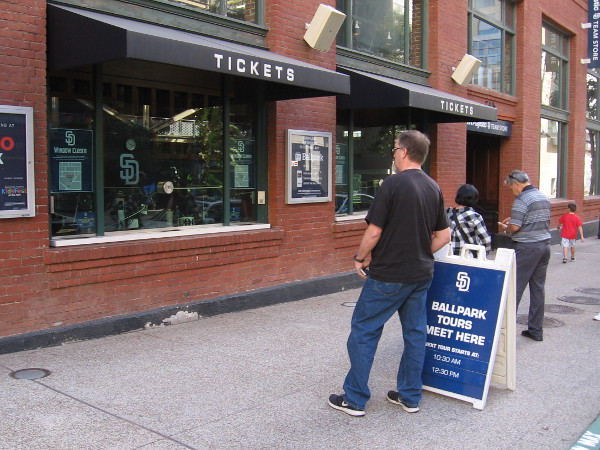 People wait by a ticket window for a fascinating ballpark tour at Petco Park in San Diego.