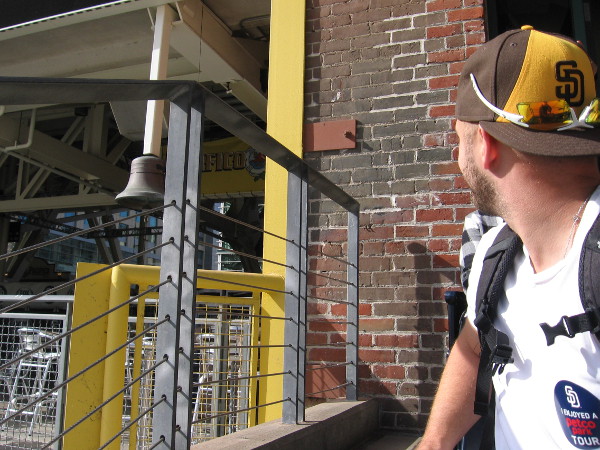 A Padres fan on the tour checks out the left field foul pole painted on a corner of the Western Metal Supply Co. Building. The tolling of the nearby mission bell connects every game to San Diego history.