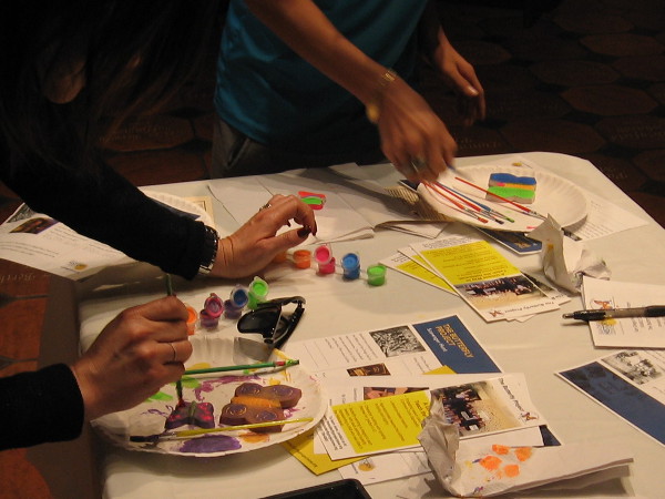 Some hands add color to the butterflies.