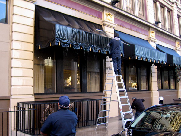 Workers were cleaning awnings over the ground floor windows of the U.S. Grant Hotel.