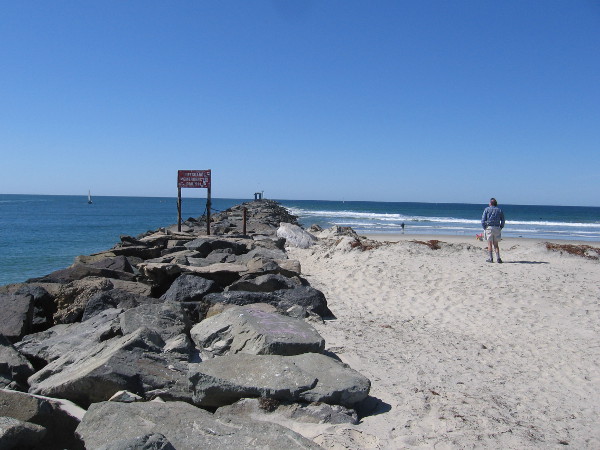 Someone approaches the foot of the rock jetty, which guards the channel into Mission Bay. This area is also called Point Medanos.