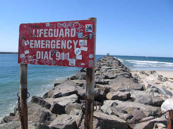 I stopped at the lifeguard emergency sign. Halfway down the jetty stands an old, abandoned bait shack, which appears like an arch that is covered with graffiti.