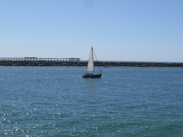 Beyond this sailboat I see the Ocean Beach Pier.