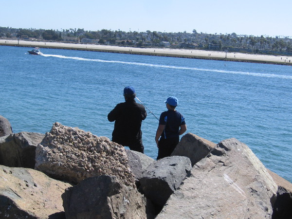 Several fishermen were casting into the blue water from the rocks.