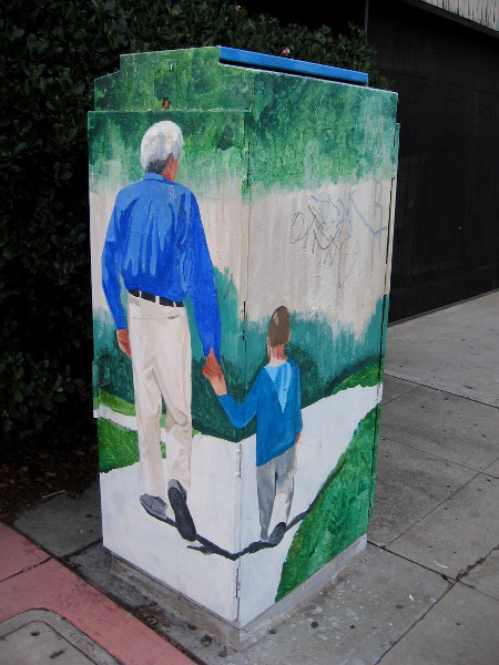 Street art in City Heights on University Avenue shows a father and son holding hands, walking down the sidewalk.