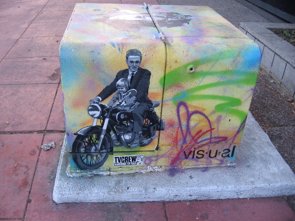 A man and small child together ride a motorcycle.