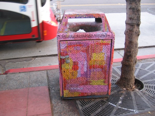 This trash can at a bus stop was brightly decorated by a street artist.