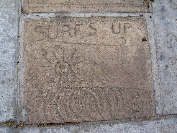 Surf's up. One of many underfoot messages in panels of concrete near the corner of Avenida de la Playa and Paseo del Ocaso.