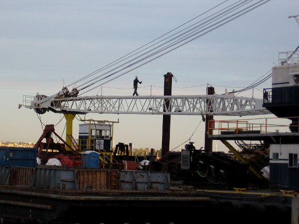 Man walks across a crane that is being used to demolish the old Anthony's Fish Grotto.