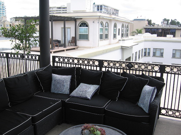 The building's penthouse apartments are beyond this comfy outdoor sofa.