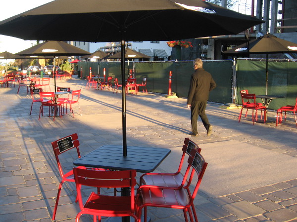 Someone walks through the piazza on a late March morning. There's still construction fencing for new buildings.