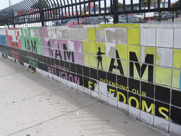 Fading art on base of wall on Broadway, around the International Association of Machinists and Aerospace Workers IAM Local 755 parking lot. I am defending our freedoms.