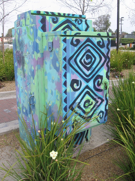 A nearby utility box is painted with colorful designs.