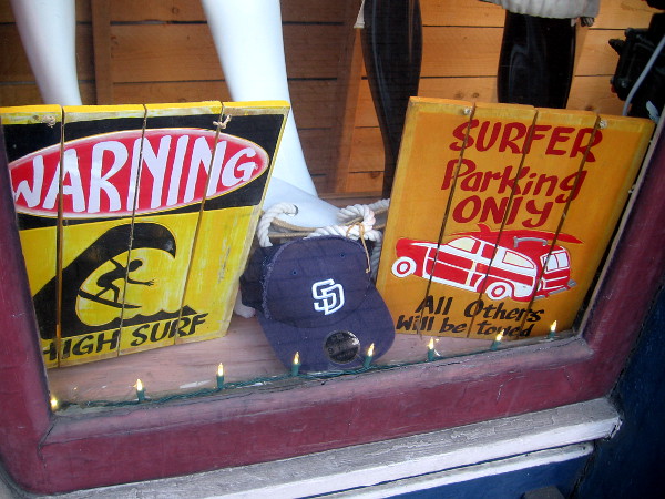 Two humorous surfing signs in the window of San Diego Trading Company Gaslamp.