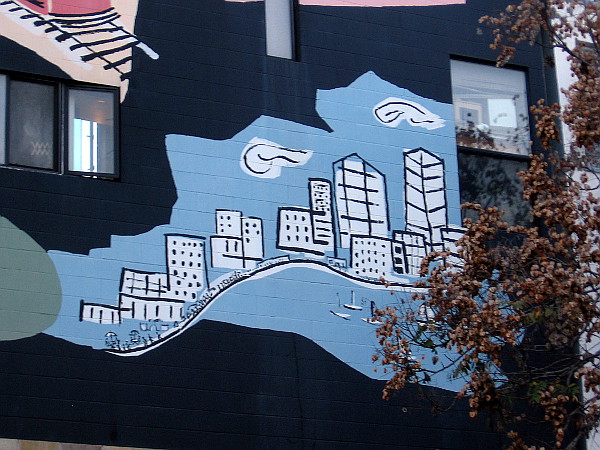 A clean, beautiful city on the water, painted on the side of a building in Little Italy.