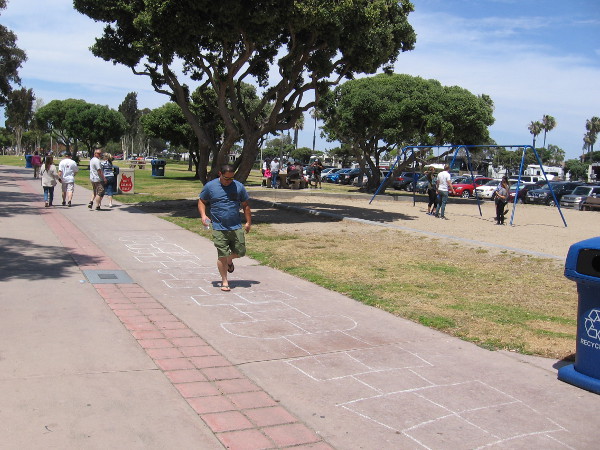 A father plays super hopscotch in the park!