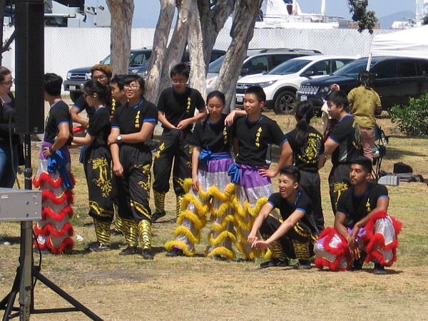 Meanwhile, some lion dancers are waiting to one side for their turn to perform.