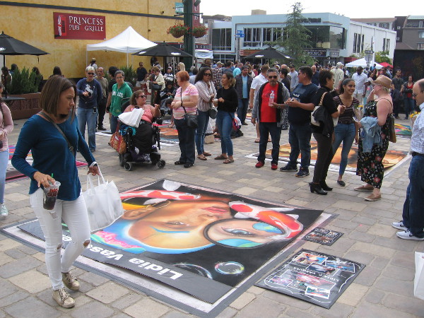 People gather around chalk art created on boards for the 2018 Mission Federal ArtWalk in Little Italy.