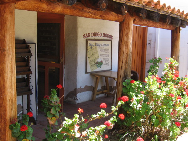 Red geraniums flourish at the rear of San Diego House.