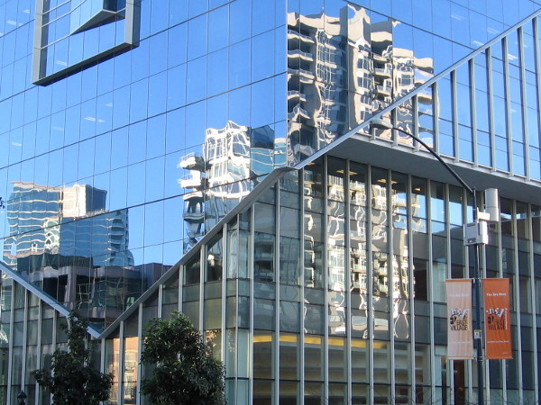 Buildings in East Village reflected in the glass windows of the headquarters of Sempra Energy.