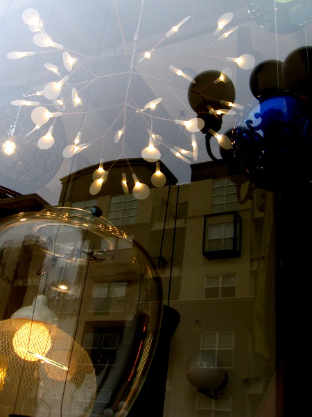 Light fixtures mingle with reflections. Magic in one window of Urban Lighting.