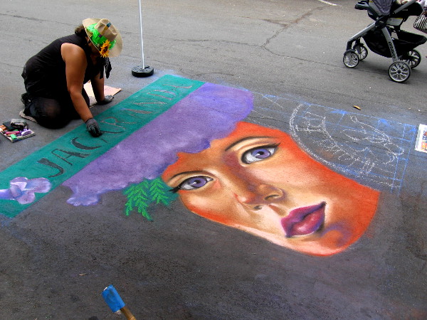 Local chalk artist Cecelia Linayao creates a beautiful jacaranda themed work of art on Date Street.