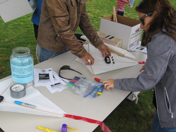 Materials at a kite creation and repair station include markers to add color to new kites.