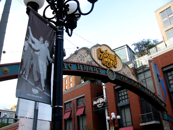 A banner hanging on a lamppost near the Gaslamp Quarter landmark sign shows a fun photo from San Diego history.
