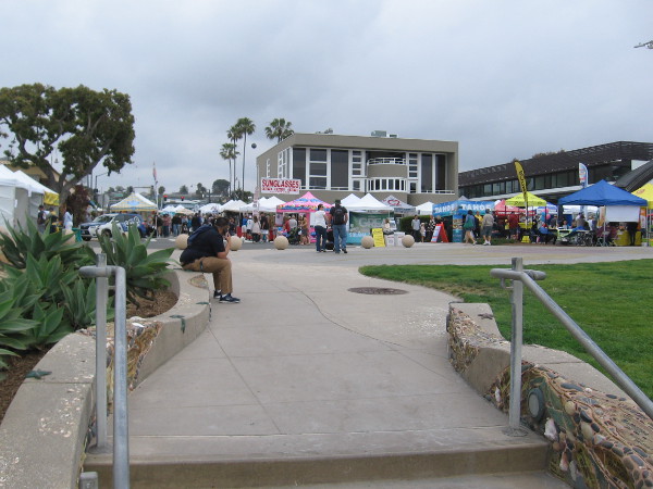 Walking back up from the beach toward the colorful festival.