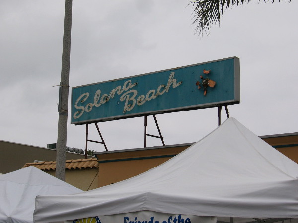 A cool Solana Beach sign above the tops of tents at Fiesta del Sol.