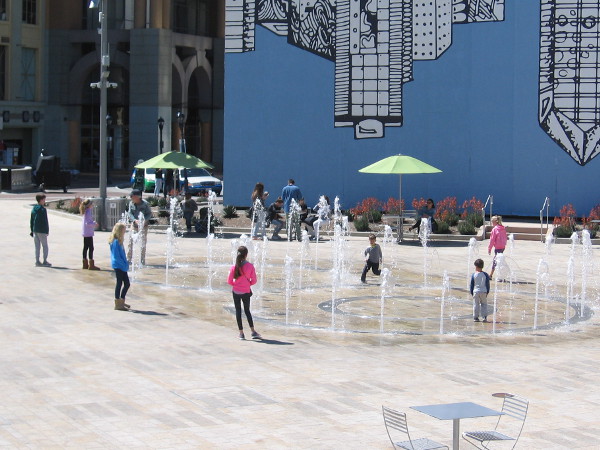 People play in the fun, splashing fountain at Horton Plaza Park.