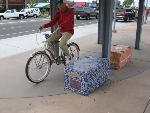 A bike rider rolls past public art. This station is part of the Coastal Rail Trail in San Diego's North County.