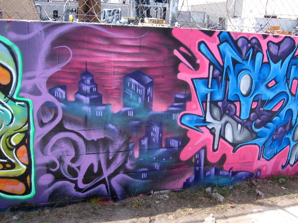 A section of bold urban art on a long wall.