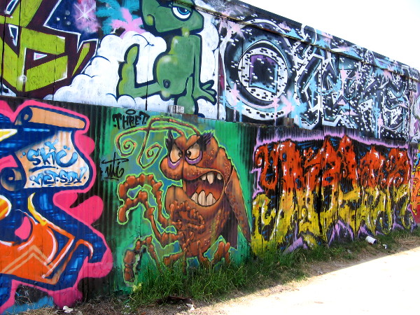 Elaborate urban artwork completely covers a long alley wall in Logan Heights.